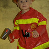 daddy bought halloween costomes early--and a certain little guy didn't want to go to school today so he could wear it.  (he did go to school but got to wear the costume after dinner.)
i'm all for cute toys and such to go with the theme--but am puzzled as to why there was a big hatchet and a small fire extinguisher included in the set??  
regardless--he made me smile so much tonight. what a character!